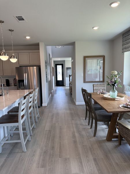 A modern kitchen-dining area with sleek appliances, wood flooring, and contemporary lighting. A modern kitchen-dining area with sleek appliances, wood flooring, and contemporary lighting.