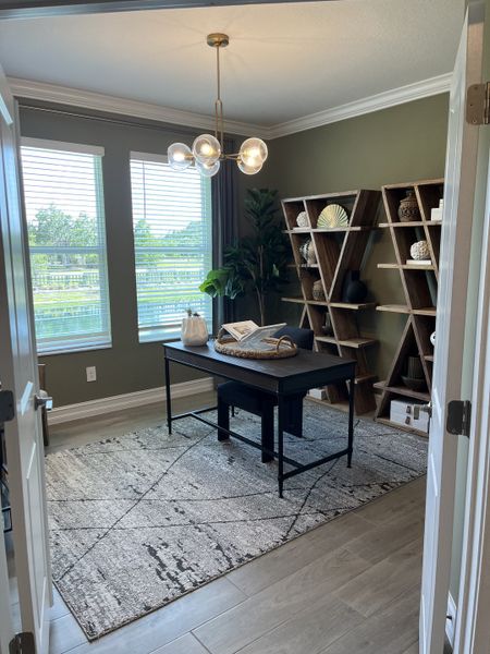 A modern home office with unique shelving, a sleek desk, and contemporary lighting creating a stylish workspace.