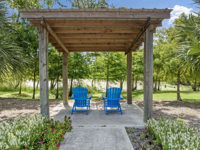 A wood gazebo with blue chairs.