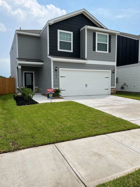 A modern two-story gray home with a manicured lawn in Park Vista at El Tesoro by LGI Homes (Houston, TX).