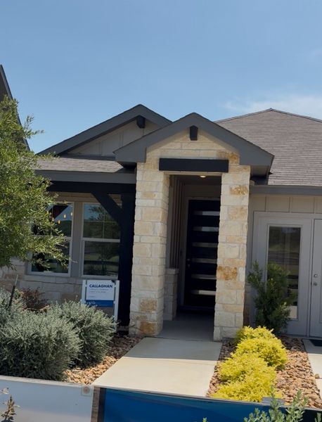 A charming stone-accented home with tidy landscaping in Estancia Ranch - Classic Series by Meritage Homes (San Antonio, TX).