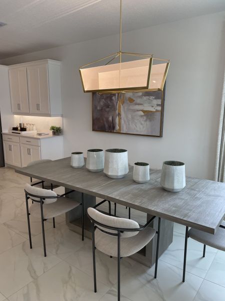 A modern dining area with a sleek wooden table, elegant lighting, and minimalist decor for a chic ambiance. A modern dining area with a sleek wooden table, elegant lighting, and minimalist decor for a chic ambiance.