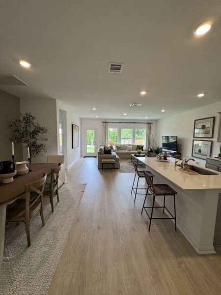 An inviting open-concept living area with sleek wood floors, cozy seating, and ample natural light.