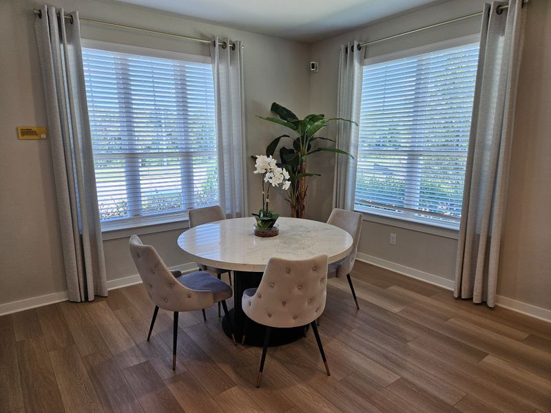 A cozy dining area featuring a round marble table, elegant chairs, and large windows with sheer curtains, creating an inviting space. A cozy dining area featuring a round marble table, elegant chairs, and large windows with sheer curtains, creating an inviting space.