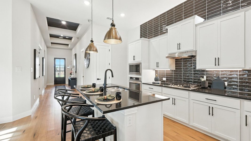 Elegant white cabinetry and black granite countertops exemplify sophistication in Green Oaks Preserve. Elegant white cabinetry and black granite countertops exemplify sophistication in Green Oaks Preserve.