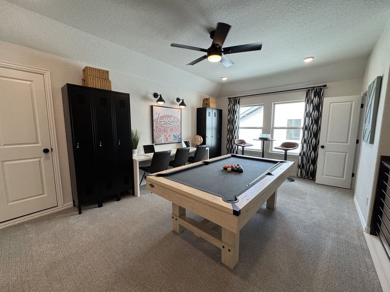 A modern game room featuring a pool table, desk space, and stylish decor with natural light filling the space. A modern game room featuring a pool table, desk space, and stylish decor with natural light filling the space.