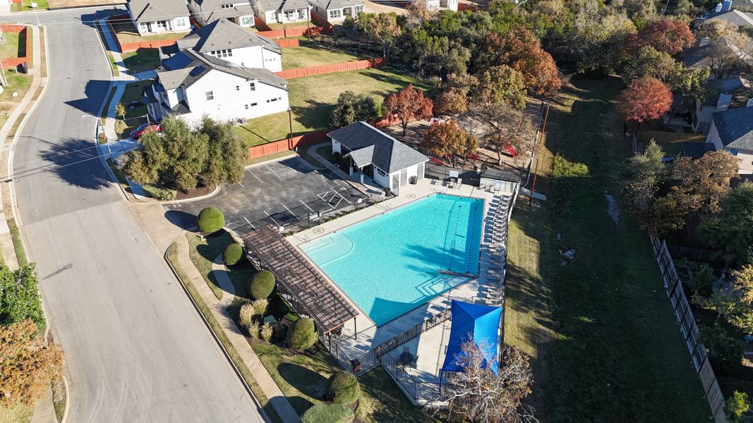 Inviting community pool with pergola and playground in Sauls Ranch East by Coventry Homes (Round Rock, TX).