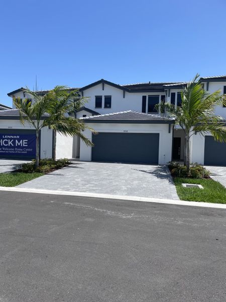 Modern white home with palm trees and a sleek driveway in Dania Preserve by Lennar (Fort Lauderdale, FL).