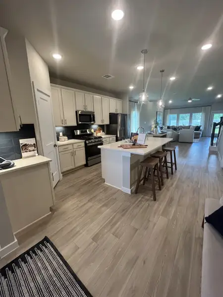 A modern kitchen with sleek cabinetry, pendant lighting, and a spacious island with seating. A modern kitchen with sleek cabinetry, pendant lighting, and a spacious island with seating.