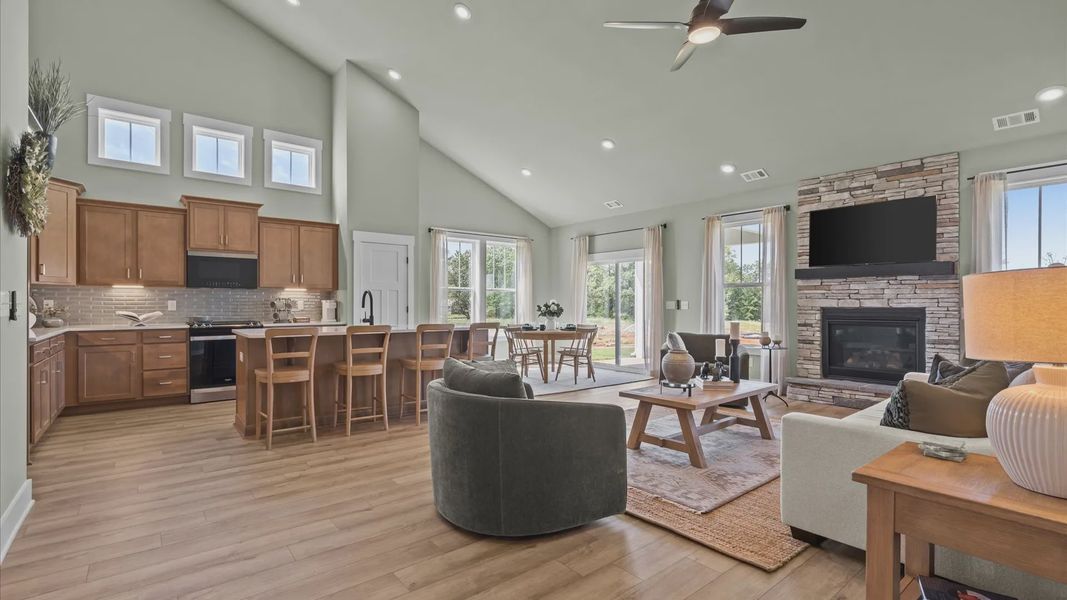 Inviting, open living spaces with vaulted ceilings, fireplace, wooden cabinetry & LVP floors at Magnolia Park by DRB Homes Inviting, open living spaces with vaulted ceilings, fireplace, wooden cabinetry & LVP floors at Magnolia Park by DRB Homes