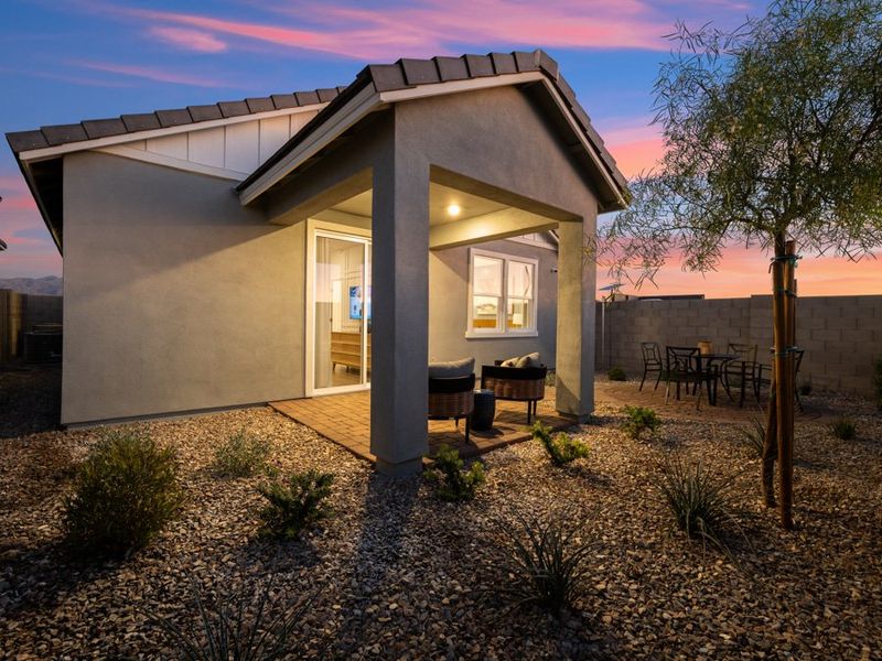 A house with a patio and a tree in the front.