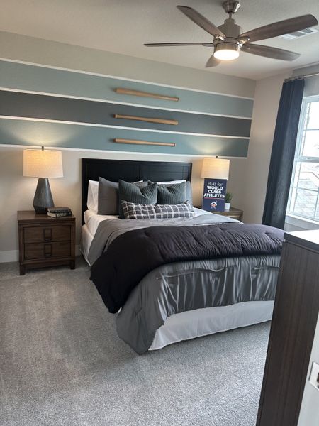 A modern bedroom with a stylish accent wall, cozy bedding, and contemporary lighting.