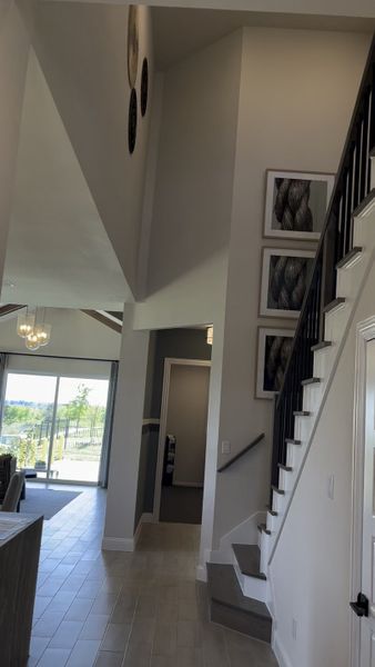 A modern entryway with high ceilings, sleek staircase, and large windows offering natural light. A modern entryway with high ceilings, sleek staircase, and large windows offering natural light.