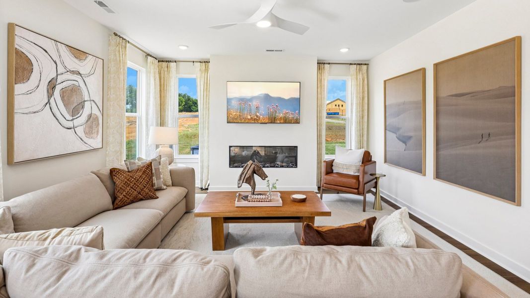 Gathering room with ceiling fan, windows, and fireplace Gathering room with ceiling fan, windows, and fireplace