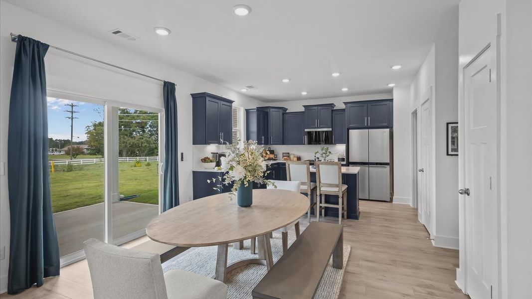 Navy cabinetry kitchen with white quartz countertops and large windows