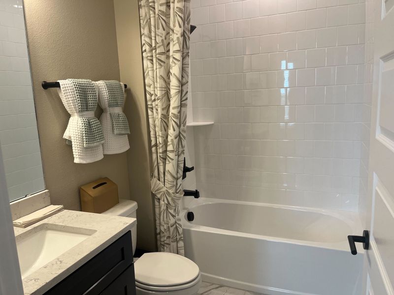 A modern bathroom featuring a sleek vanity, white subway tiles, and a patterned shower curtain for a touch of elegance. A modern bathroom featuring a sleek vanity, white subway tiles, and a patterned shower curtain for a touch of elegance.