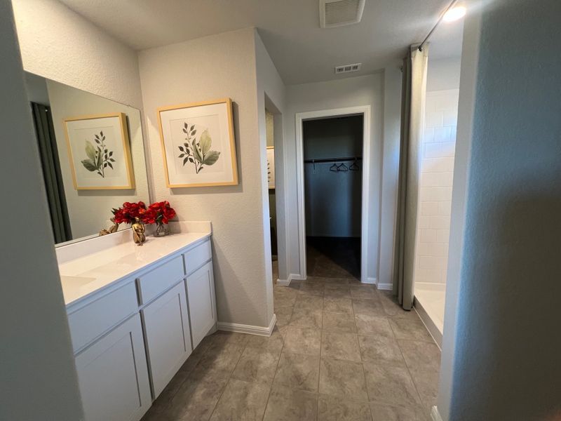 A sleek bathroom with white cabinetry, decorative art, and a spacious tiled shower for a modern touch. A sleek bathroom with white cabinetry, decorative art, and a spacious tiled shower for a modern touch.