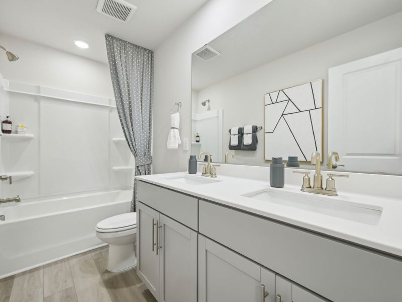 Adjacent to the secondary bedrooms is a luxurious bath featuring dual sinks.