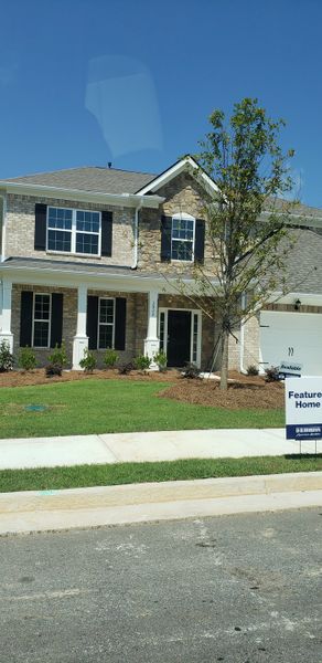 A charming two-story brick and stone home in Butner Estates by D.R. Horton, showcasing a lush green lawn (South Fulton, GA).