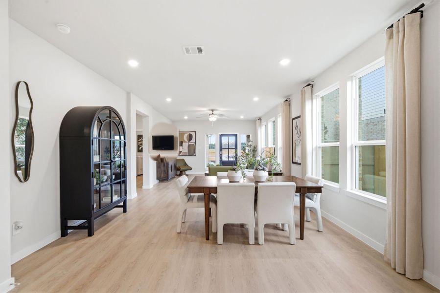 A large dining room with a wood floor.