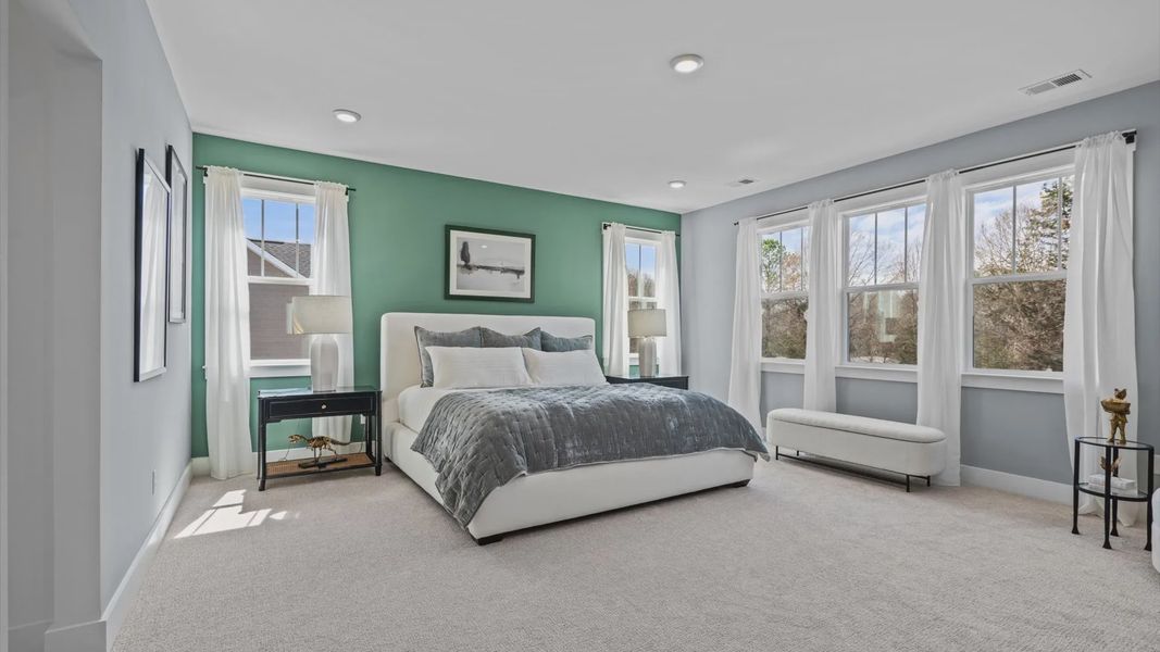 Large primary suite with large windows, plush carpet, and ceiling fan at Pinebrook by DRB Homes in Woodruff, SC Large primary suite with large windows, plush carpet, and ceiling fan at Pinebrook by DRB Homes in Woodruff, SC