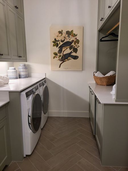 Sleek laundry room with modern appliances, herringbone tile, and stylish cabinetry. Sleek laundry room with modern appliances, herringbone tile, and stylish cabinetry.