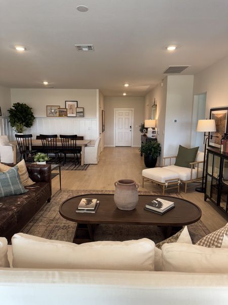 An elegant living-dining area with warm wood floors, cozy seating, and tasteful art. Perfect for gatherings and relaxation.