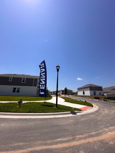 A modern community with spacious homes and well-maintained lawns at Wellness Ridge: Manor Collection by Lennar (Clermont, FL).