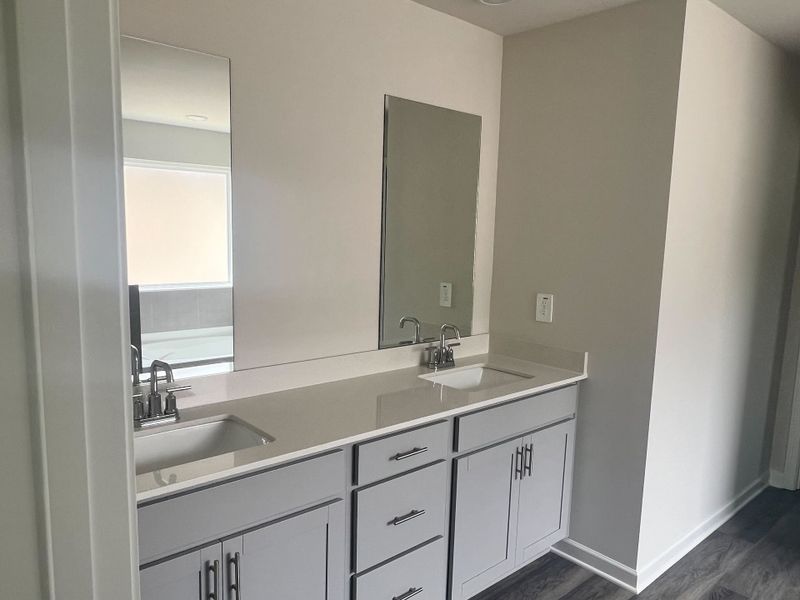 A sleek bathroom vanity with dual sinks, large mirrors, and elegant cabinetry. A sleek bathroom vanity with dual sinks, large mirrors, and elegant cabinetry.