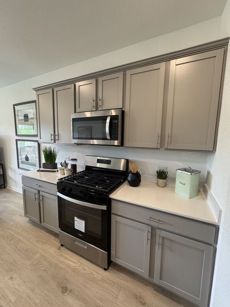A sleek kitchen with stainless steel appliances, gray cabinetry, and elegant countertops for a modern look.