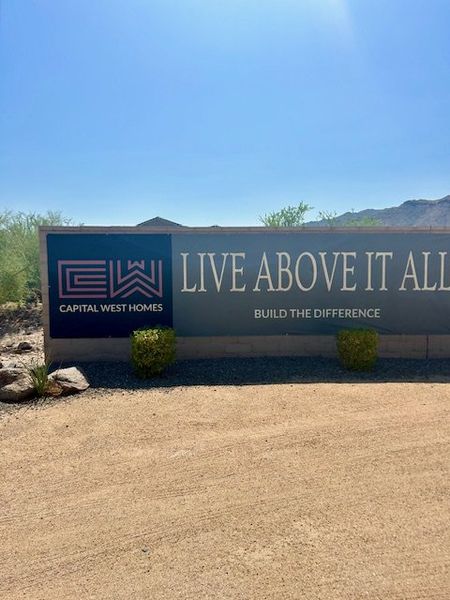A welcoming sign for Highlands at Verrado by Capital West Homes in Buckeye, AZ, surrounded by desert landscaping.