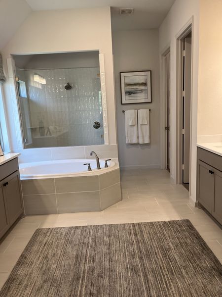 A spacious bathroom with a sleek soaking tub, double vanity, and neutral tones for a calming retreat. A spacious bathroom with a sleek soaking tub, double vanity, and neutral tones for a calming retreat.