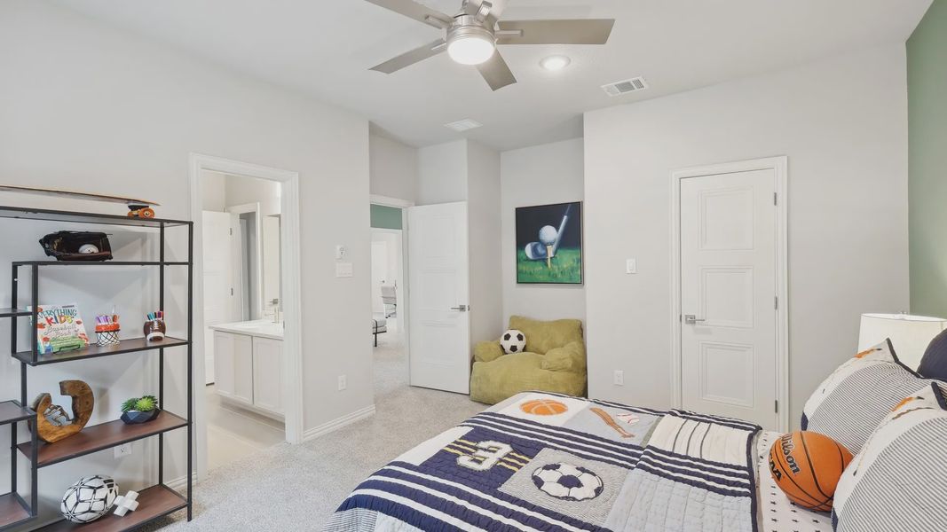 Elegant children's bedroom features luxury carpeting, chic ceiling fan, and modern ensuite in Wildflower Ranch. Elegant children's bedroom features luxury carpeting, chic ceiling fan, and modern ensuite in Wildflower Ranch.