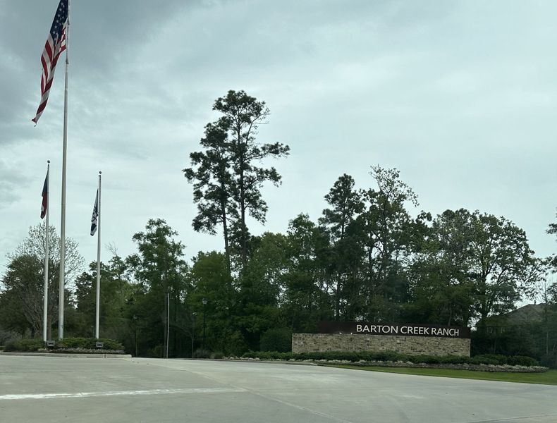 Entrance of Barton Creek Ranch by Long Lake Ltd. in Conroe, TX, with flagpoles and lush greenery lining the driveway. Entrance of Barton Creek Ranch by Long Lake Ltd. in Conroe, TX, with flagpoles and lush greenery lining the driveway.