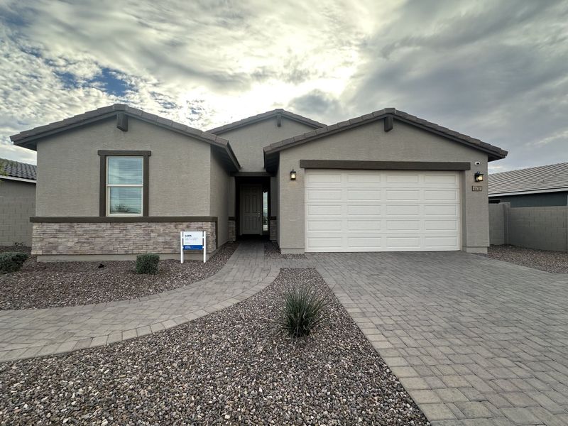 A modern ranch-style home with stone accents and a paver driveway in San Tan Groves by Meritage Homes (San Tan Valley, AZ).