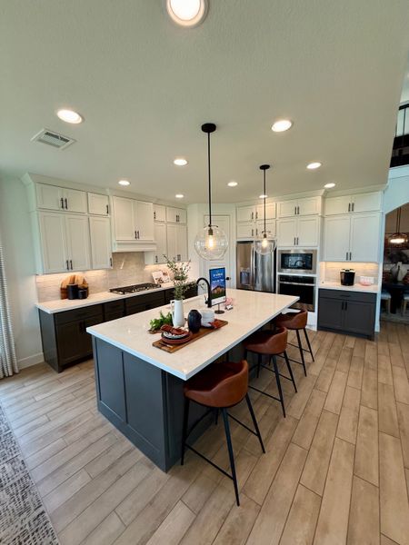 A modern kitchen with a large island, stylish pendant lights, and sleek cabinetry for a contemporary touch.