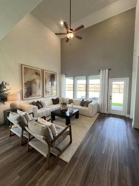 An elegant living room with high ceilings, a chic sectional sofa, warm wood floors, and stylish decor elements. An elegant living room with high ceilings, a chic sectional sofa, warm wood floors, and stylish decor elements.