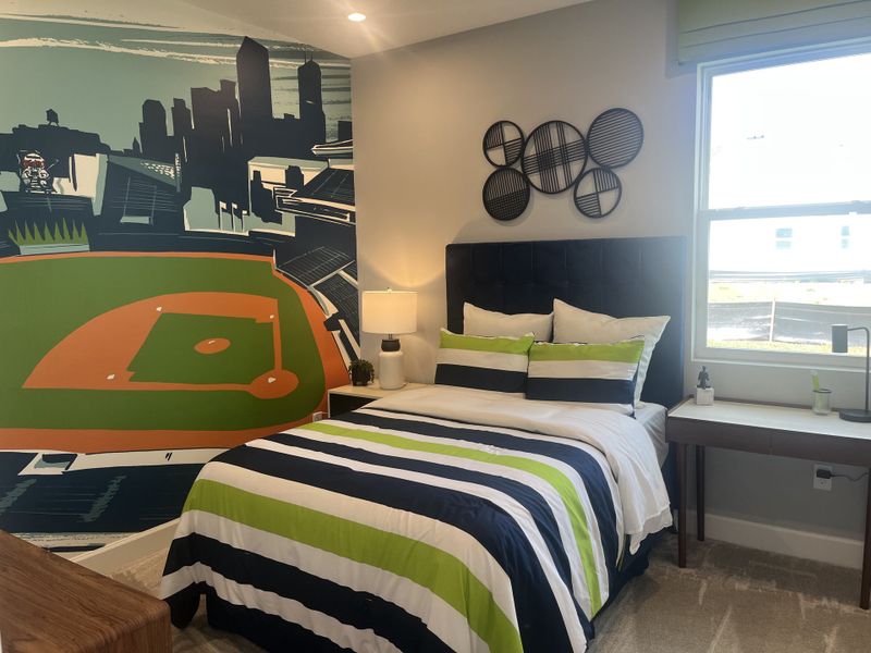 A vibrant bedroom featuring a baseball-themed mural, striped bedding, and modern decor elements.