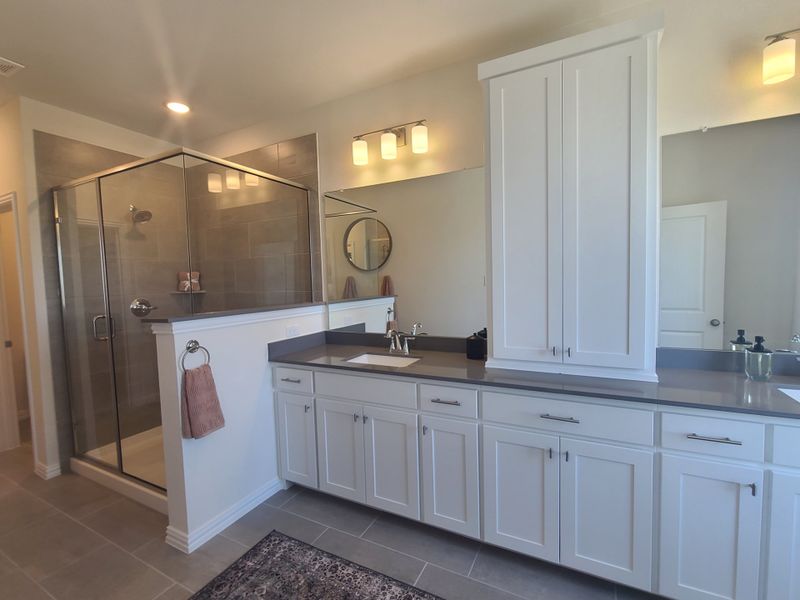 A modern bathroom featuring a large glass shower, sleek double vanity with white cabinets, and elegant lighting fixtures. A modern bathroom featuring a large glass shower, sleek double vanity with white cabinets, and elegant lighting fixtures.