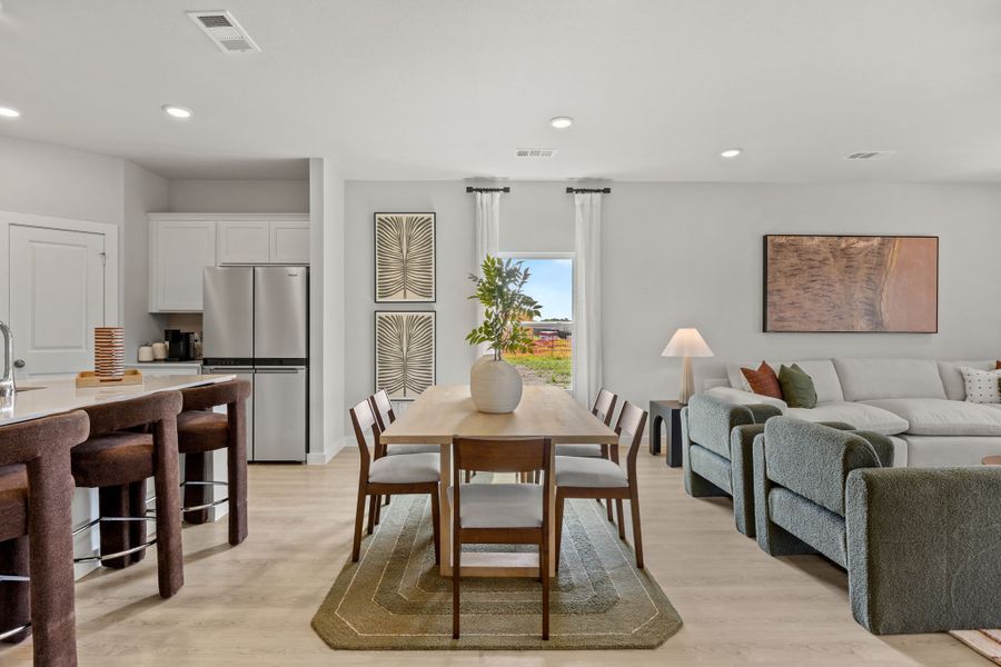 A large living room with a dining table and chairs. A large living room with a dining table and chairs.