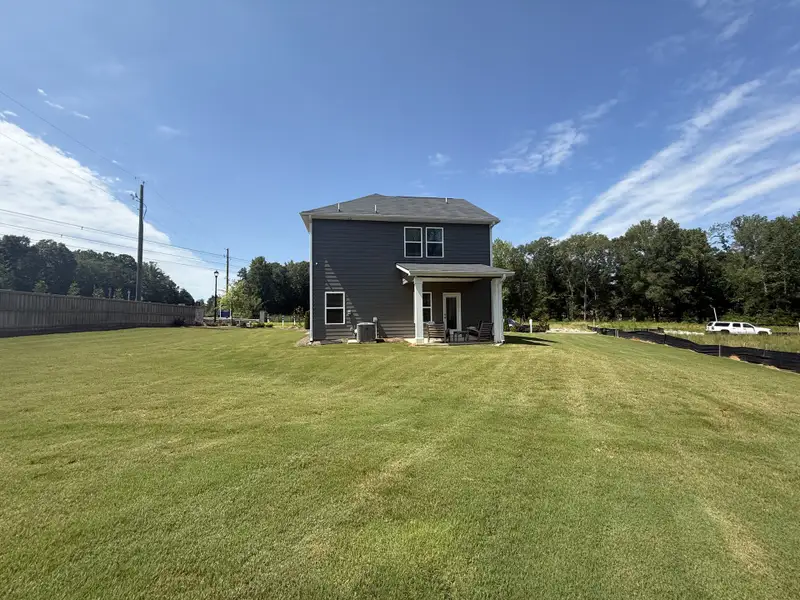 A spacious backyard with a modern gray home in Campground Crossing by Dream Finders Homes (Mcdonough, GA). A spacious backyard with a modern gray home in Campground Crossing by Dream Finders Homes (Mcdonough, GA).