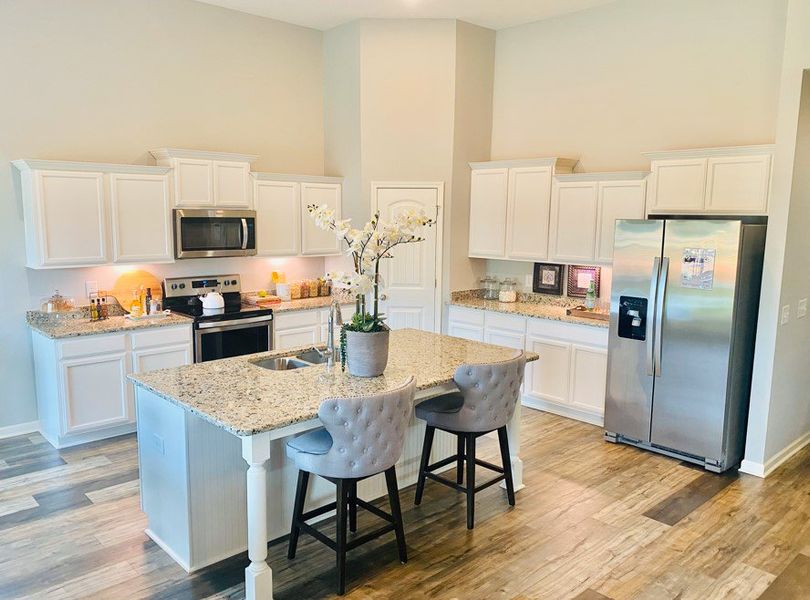 This bright and inviting kitchen features sleek white cabinetry, granite countertops, stainless steel appliances—including a side-by-side refrigerator, built-in microwave, and electric range This bright and inviting kitchen features sleek white cabinetry, granite countertops, stainless steel appliances—including a side-by-side refrigerator, built-in microwave, and electric range