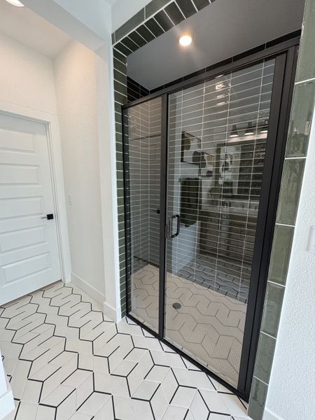A modern bathroom with sleek glass shower doors, geometric tiles, and elegant lighting. A modern bathroom with sleek glass shower doors, geometric tiles, and elegant lighting.