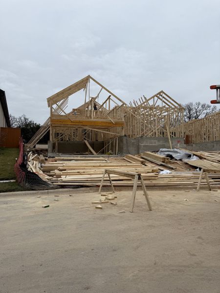 Construction of a new home in Parkside Peninsula by Highland Homes, Georgetown, TX, showcasing wooden frameworks in progress.