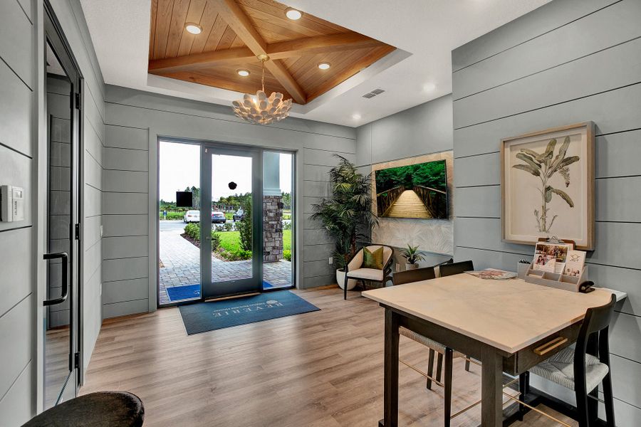 Sales office lobby with wood tray ceiling, shiplap walls, hardwood floors, and glass entry doors