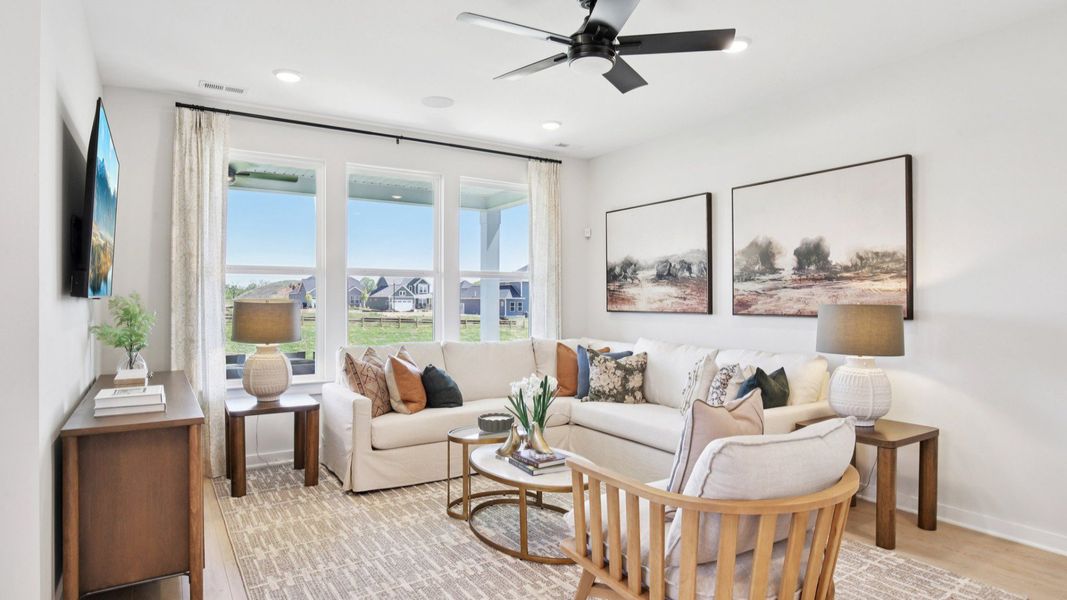 Gathering room with hard surface flooring, ceiling fan, and windows Gathering room with hard surface flooring, ceiling fan, and windows