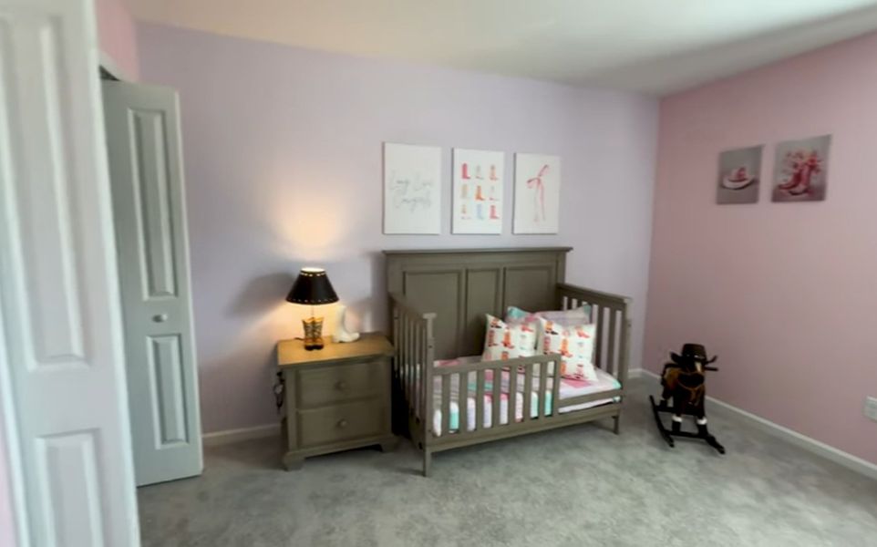 A cozy child's room with soft pastel walls, a wooden crib, playful decor, and a plush carpet.
