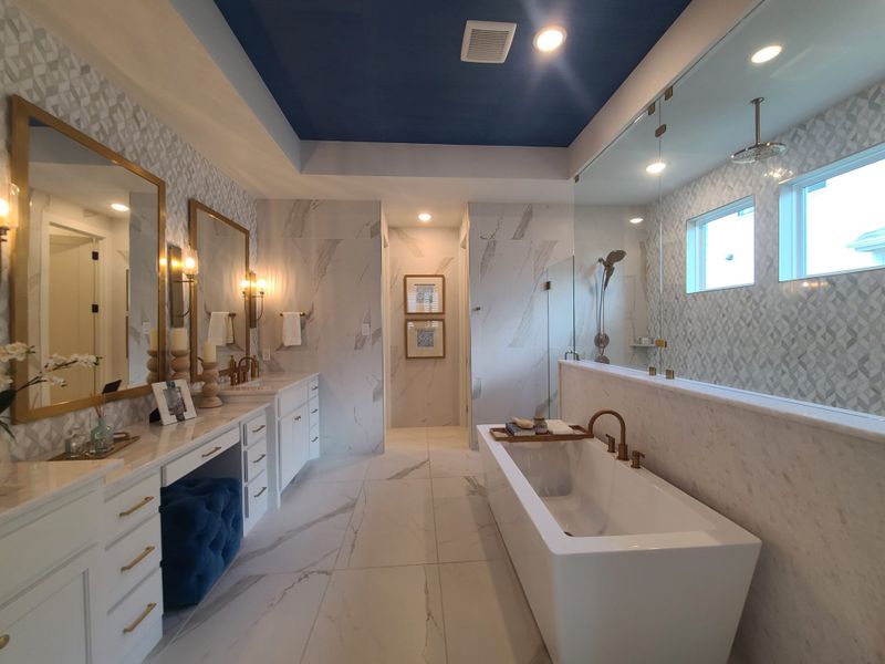 Luxurious bathroom with a freestanding tub, marble details, dual sinks, and elegant lighting.