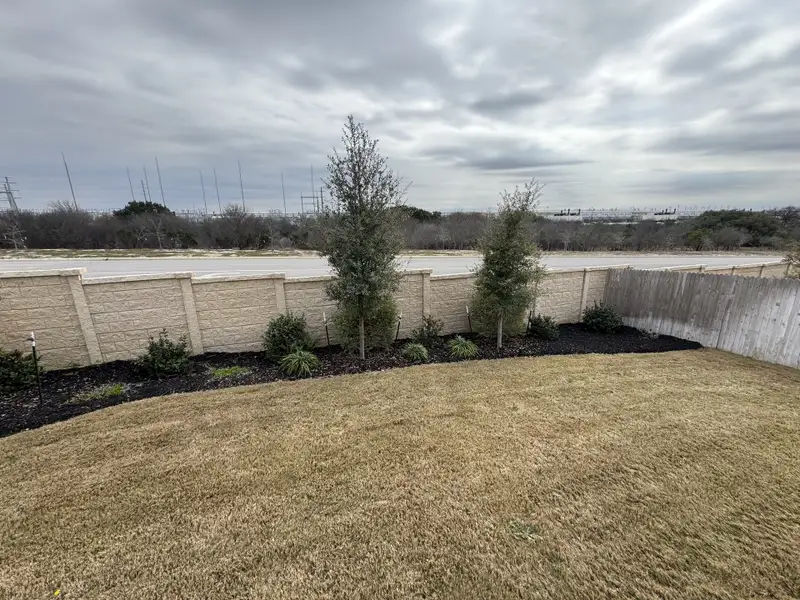 A landscaped yard with a privacy fence in Hunters Ranch by Chesmar Homes, San Antonio, TX. A landscaped yard with a privacy fence in Hunters Ranch by Chesmar Homes, San Antonio, TX.
