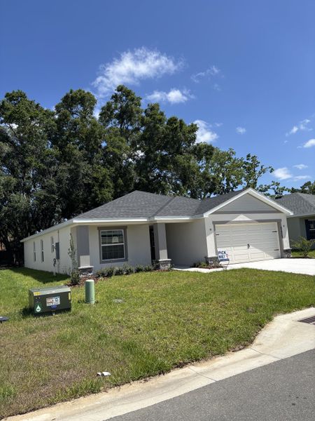 A charming single-story home with a spacious lawn in Bennah Oaks by Highland Homes of Florida (Belleview, FL).